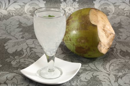 Téléchargez les photos : Eau de coco dans un verre avec noix de coco - en image libre de droit