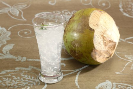 Téléchargez les photos : Eau de coco dans un verre avec noix de coco - en image libre de droit
