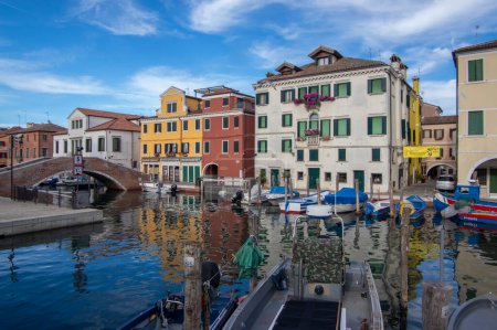 Foto de Chioggia, ITALIA - 8 de junio de 2022: Calles pintorescas de la ciudad de Chioggia con canal de agua, barcos y edificios antiguos a la luz del sol - Imagen libre de derechos