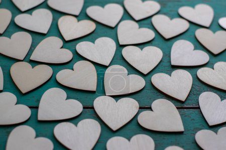 Téléchargez les photos : Amour Valentines fond de jour, groupe de cœurs en bois clair répartis sur vintage bleu vert table rayée, plat couché un par un morceau - en image libre de droit