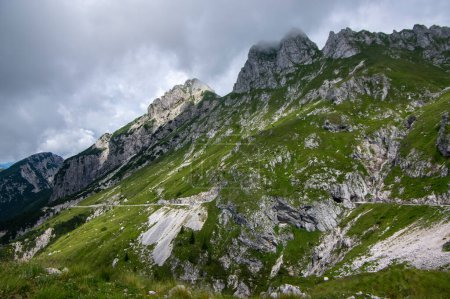 Foto de Mala Spice Cime Verdi alcanza su punto máximo en la silla de montar Mangart, la carretera panorámica más alta de Eslovenia, nubes pesadas antes de la lluvia de verano - Imagen libre de derechos