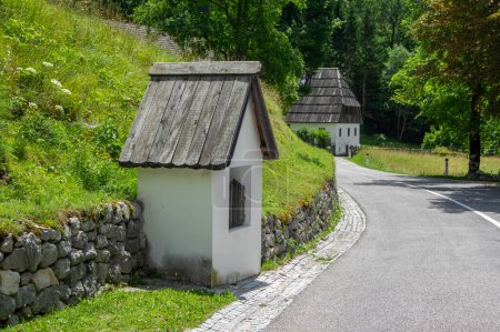 Téléchargez les photos : Bovec, Trenta Valley, Slovenia - July 6, 2022: picturesque houses with old Lady of Loreto Church surrounded with greenery and alpine mountains - en image libre de droit