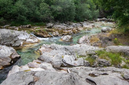 Amazing wild water in mala korita Soce valley, small pure clear turquoise flowing stream through stones gorge