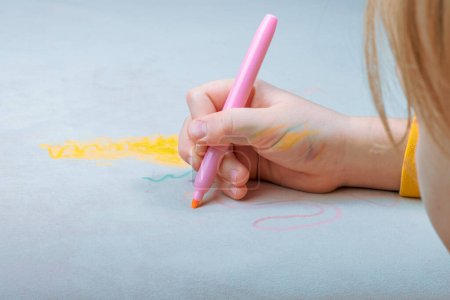 Le dessin de l'enfant à la main avec stylo feutre rose sur le rembourrage gris du canapé. tache sale de la vie quotidienne pour le lavage et le concept propre. Photo de haute qualité