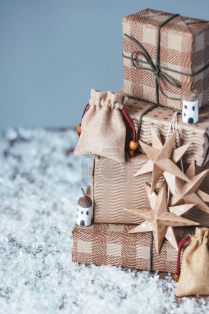 Téléchargez les photos : Arbre de Noël avec cadeaux sur la neige sur fond gris. Bricolage décoration de Noël durable biologique. Consommation éthique et concept écologique. - en image libre de droit