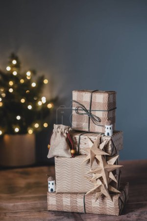 Téléchargez les photos : Cadeaux de Noël dans un emballage écologique en papier artisanal avec des étoiles sur une table en bois. Eco-friendly Décoration de vacances. Consommation éthique et concept écologique. - en image libre de droit