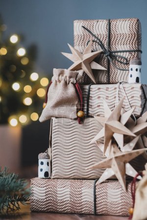 Téléchargez les photos : Arbre de Noël avec des cadeaux sur fond en bois près du sapin de Noël. Bricolage décoration de Noël durable biologique. Zéro déchet et concept sans plastique. Photo de haute qualité - en image libre de droit