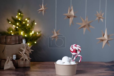 Foto de Helado cremoso en eco box con caramelos navideños sobre guirnaldas de fondo de luz. Decoraciones ecológicas. Postre vegano festivo. Feliz Navidad. Foto de alta calidad - Imagen libre de derechos