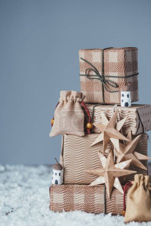 Téléchargez les photos : Arbre de Noël avec cadeaux sur la neige sur fond gris. Bricolage décoration de Noël durable biologique. Consommation éthique et concept écologique. espace pour le texte. Photo de haute qualité - en image libre de droit