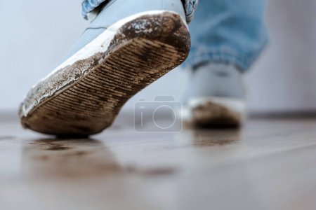 Huella de barro en zapatos blancos y piso. La vida cotidiana mancha sucia. Foto de alta calidad