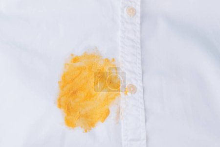 Foto de Mancha amarilla sucia en una camisa blanca. Ropa estropeada. aislado. Vista superior. Foto de alta calidad - Imagen libre de derechos