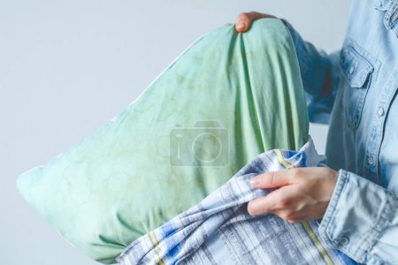 Photo for Female hands change a pillowcase from dirty saliva stains on a pillow for long-term use. Cleaning concept. High quality photo - Royalty Free Image
