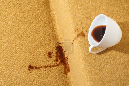 Photo for Accidental coffee spill on the sofa, creating a brown stain that marred the upholstery, sofa or couch. Spoiled fabric-covered. Cleaning and stain removal concept. High quality photo - Royalty Free Image