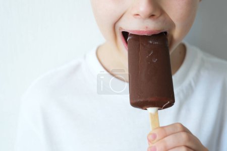 Foto de Cerrar niño mordiendo helado de chocolate. Dulce desierto. Concepto de salud dental. Foto de alta calidad - Imagen libre de derechos