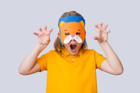 Das Kind trägt eine Bärenmaske auf grauem Hintergrund. DIY-Spielzeug, verkleiden Kostüme Maske, Party-Zubehör, Geburtstagsfeier Gefälligkeiten, Spielzubehör, Fotoautomaten Requisiten für Kinder. Hochwertiges Foto