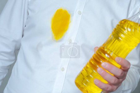 A dirty yellow grease stain of oil or sauce on a white shirt. Spoiled clothes. daily life stain concept. High quality photo