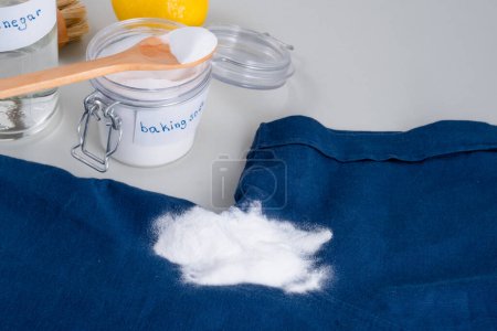 Using baking soda for blood stain removal on clothes. Eco-friendly cleaning products white vinegar, baking soda, lemon, brush. Zero waste concept. top view. High quality photo