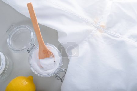 Téléchargez les photos : Le nettoyage maison de la sueur jaune tache les aisselles sur un T-shirt blanc. Produits nettoyants écologiques vinaigre blanc, bicarbonate de soude, citron. Adopter un mode de vie zéro déchet. . Photo de haute qualité - en image libre de droit