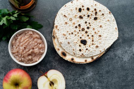 Handmade round Matzah in a plate on a concrete background. Saved Jewish Pesach Tradition. Jewish Passover celebrations. top view. High quality photo