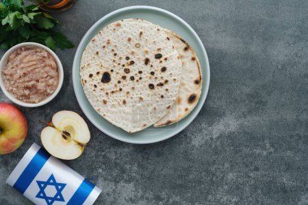 Handmade round Matzah in a plate on a concrete background. Saved Jewish Pesach Tradition. Jewish Passover celebrations. top view. High quality photo