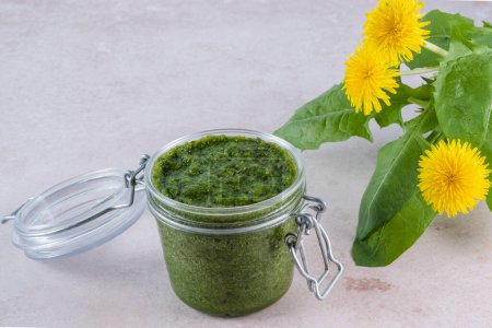 Creamy dandelion greens pesto in jar on a white background, top view. Appetizer, condiment or topping. Healthy vegan food. High quality photo