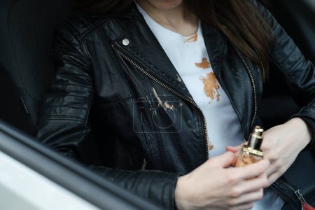 Young woman driving spilled cosmetic cream on a leather jacket. Cosmetic stains on the clothes. Liquid foundation cream. daily life stain and cleaning concept. High quality photo