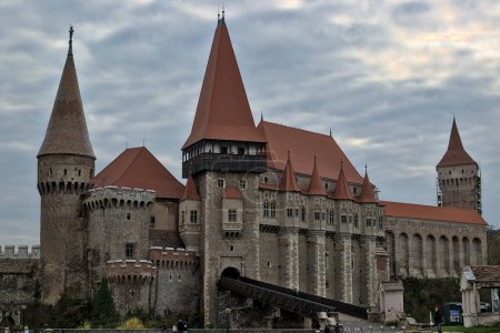 Foto de Hunedoara, Romania - 17 October, 2022: view of the landmark 15th-century Corvin Castle in Transylvania. Gothic chateau in the Renaissance style. One of the largest castles in Europe. On a cloudy day. - Imagen libre de derechos