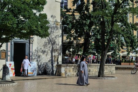 Foto de Cracovia, Polonia - 25 de julio de 2022: Una monja señorial en la plaza Rynok cerca de la antigua iglesia de St. Wojciech. - Imagen libre de derechos