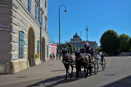 Photo for Vienna, Austria - June 29, 2023: Horse-drawn carriage with tourists on the street in the historical center of Vienna. Very popular transport. Streets and architecture of the old city. - Royalty Free Image