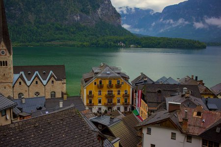 Hallstatter lake and Hallstatt village with cloudy sky in Austrian Alps. Natural colorful evening light on a foggy day. One of the most popular tourist destinations in Austria.