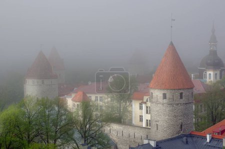 Photo for The towers of old Tallinn in a thick fog. An unusual view of an Estonian landmark. - Royalty Free Image