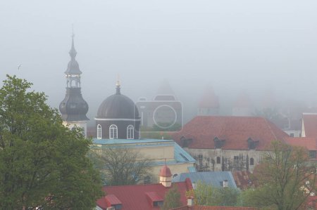 Photo for The towers and churches of old Tallinn in a thick fog. An unusual view of an Estonian landmark. - Royalty Free Image