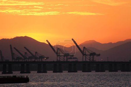 Photo for Silhouette of cranes on the pier in the evening. Rio de Janeiro, Brazil. - Royalty Free Image