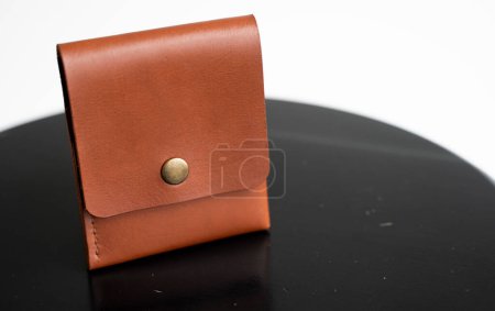 Téléchargez les photos : Orange mens business leather card holder on a black chair with a white background. Mens accessories. - en image libre de droit
