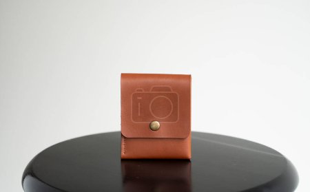 Téléchargez les photos : Orange mens business leather card holder on a black chair with a white background. Mens accessories - en image libre de droit