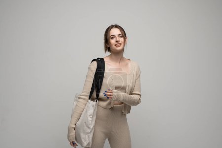 Photo for Happy, smiling brunette young woman carrying reusable cotton bag. Concept of recycle for better environment. No plastic - Royalty Free Image