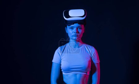 Téléchargez les photos : Portrait de femme brune adolescent en vr lunettes de réalité virtuelle prêt à jouer dans le jeu en ligne avec simulation 3D. Réalité virtuelle, technologie, divertissement et personnes - en image libre de droit
