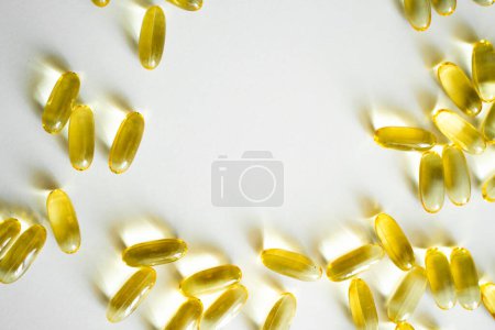 Téléchargez les photos : Fermer les capsules d'Oméga 3 sur fond blanc. Concept de soins de santé. Pilule médicale ou modèle de capsule de vitamines. Concept de médecine, de santé ou de pharmacie - en image libre de droit