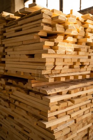 Téléchargez les photos : La transformation du bois. Panneaux de bois empilés à l'entrepôt de bois dans une industrie du bois. Empilés avec du bois de pin. Séchage du bois brut dans l'entrepôt de bois - en image libre de droit