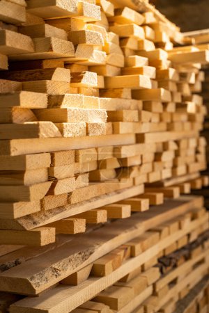 Téléchargez les photos : Des planches de bois empilées en gros plan à l'entrepôt de bois. Pile de bois séchant à l'air. Séchage à l'air. Bois pour la construction de maisons. Industrie du bois - en image libre de droit