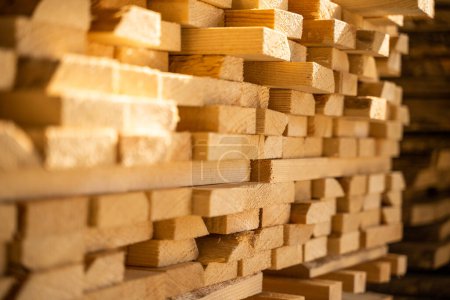 Téléchargez les photos : Planches et poutres en bois dans un entrepôt de bois d'oeuvre intérieur. Empilés avec du bois de pin. Panneau bordé plié. Atelier de récolte du bois - en image libre de droit
