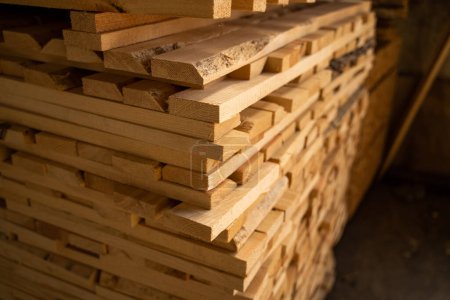 Téléchargez les photos : Des planches de bois empilées en gros plan dans un entrepôt de bois extérieur. Contexte des conseils d'administration. Industrie du bois - en image libre de droit