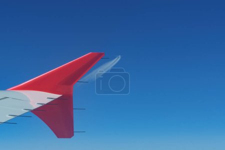 Photo for View of an airplane winglet during flight and incoming airplane in the distance. Aviation, aerodynamics and air traffic concepts - Royalty Free Image