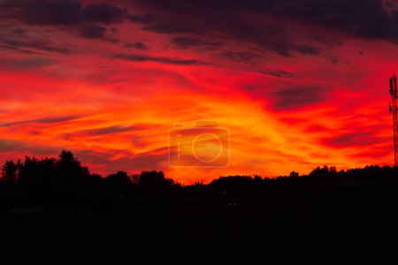 Foto de Cielo rojo atardecer muy dramático en el norte por la noche sobre el bosque y zona residentail - Imagen libre de derechos
