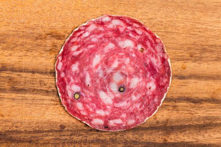 Téléchargez les photos : Tranche de saucisses de salami sur planche de bois isolée - en image libre de droit