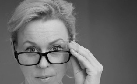 Téléchargez les photos : Femme avec des lunettes sur l'écran avec fond gris - en image libre de droit