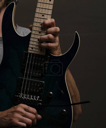 Téléchargez les photos : Jouer de la guitare électrique avec fond gris - en image libre de droit