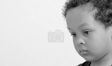 Téléchargez les photos : Petit garçon au visage triste dans la pauvreté sur fond blanc - en image libre de droit
