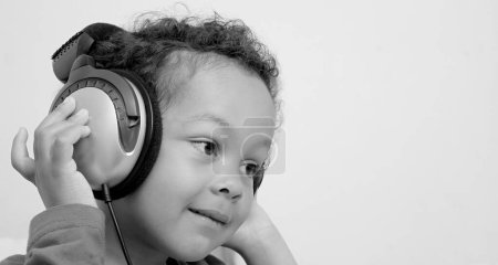 Téléchargez les photos : Garçon avec écouteurs appréciant la musique - en image libre de droit