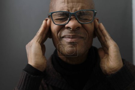 man suffering from deafness and hearing loss on grey background 
